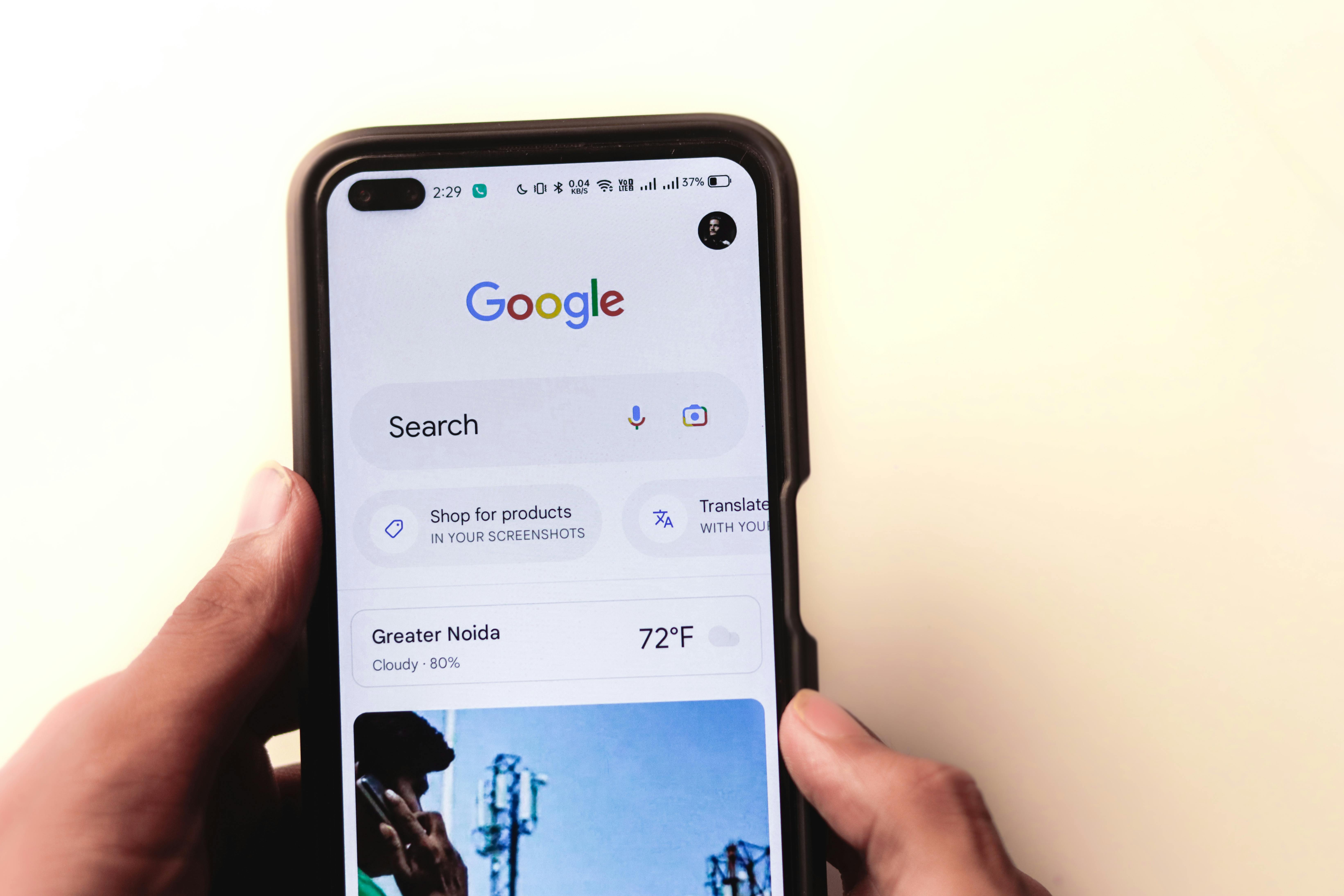 A person holding a phone with Google Search.